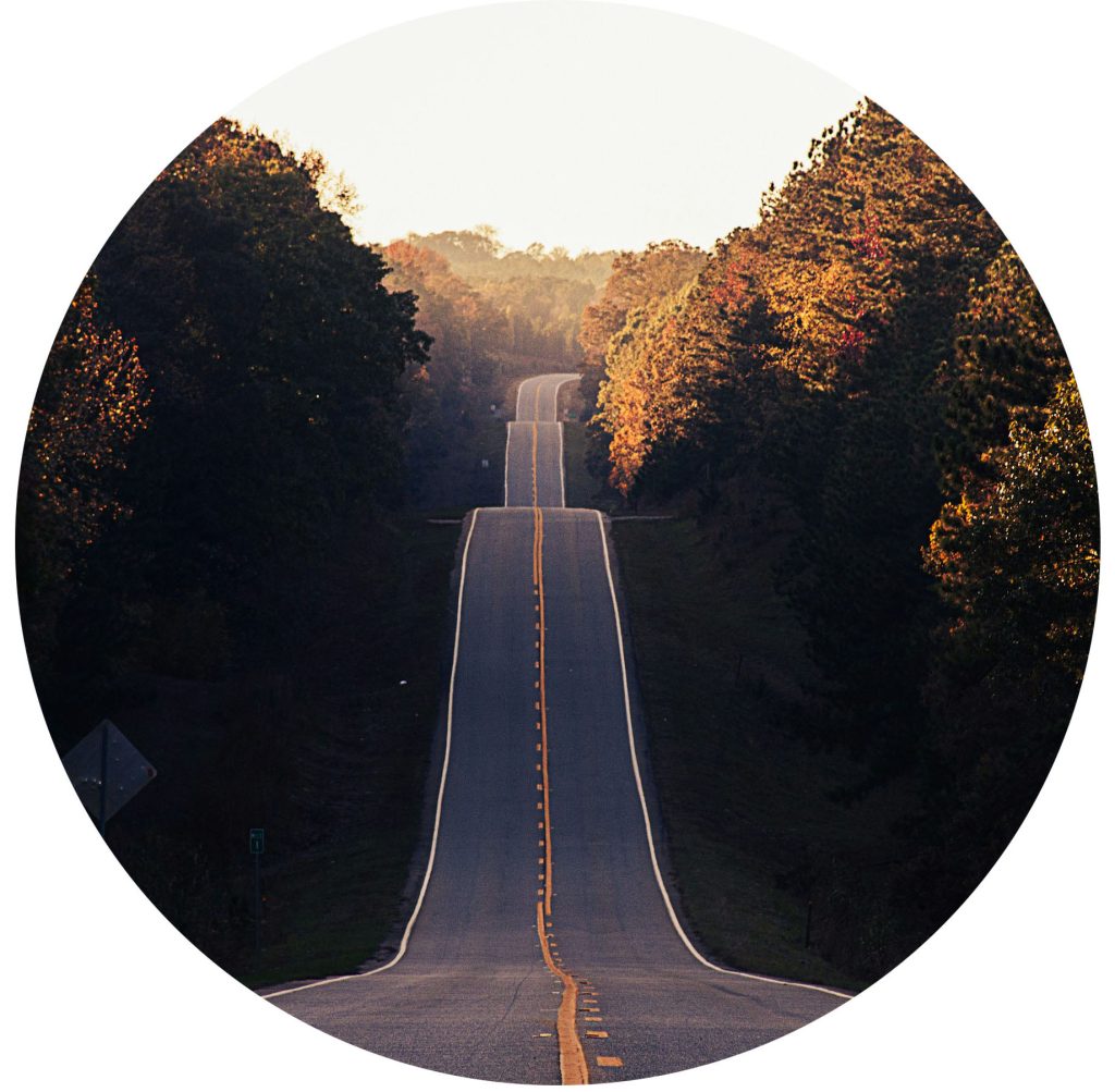 Hügelige Straße, die durch Berge und Täler führt, symbolisiert die Führung durch Wandel und das Sicherstellen der Zukunft mit digital-agilen Transformationen.