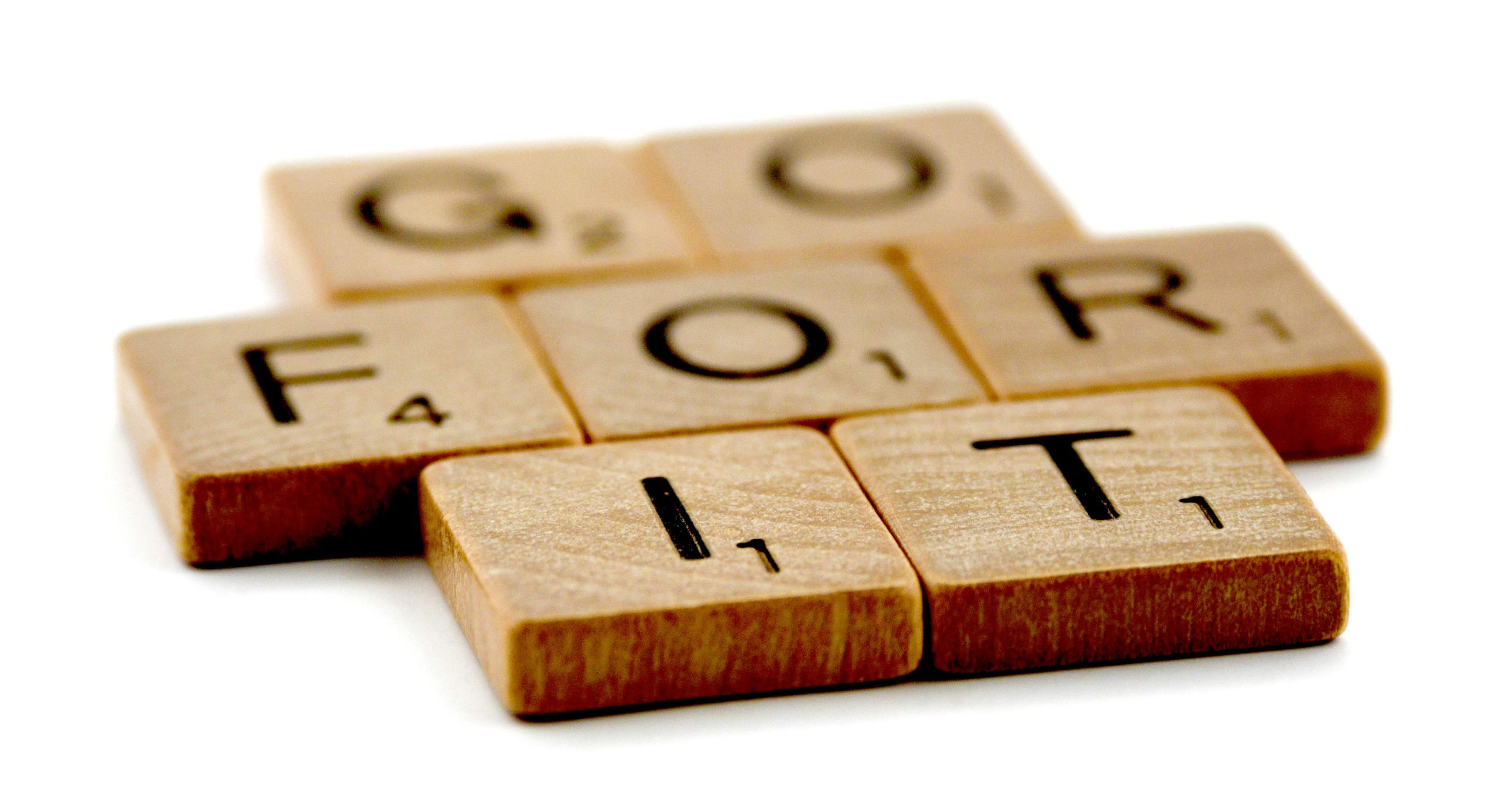 Scrabble-Fliesen formen den ermutigenden Spruch 'Go for it', motivierend Führungskräfte und Teams, die sechs Erfolgsversprechen in New Leadership und digitaler Transformation mutig anzugehen.