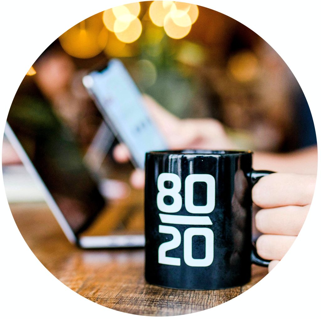 Tasse mit Pareto-Prinzip 80:20 auf einem Bürotisch, steht für Empowerment und effiziente Strategien im Coaching und Advisory.
