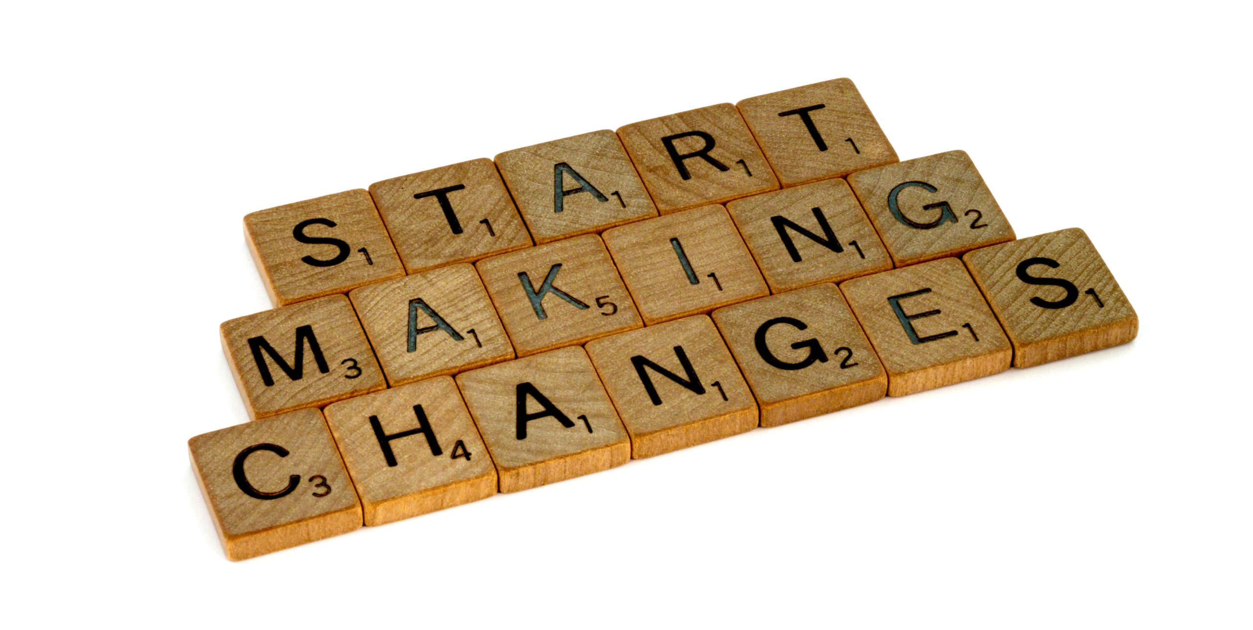 Scrabble-Fliesen mit 'Start making changes' als Aufruf zur Veränderung, unterstreicht die Bedeutung von proaktivem Handeln in digitaler Transformation und KI-Integration.